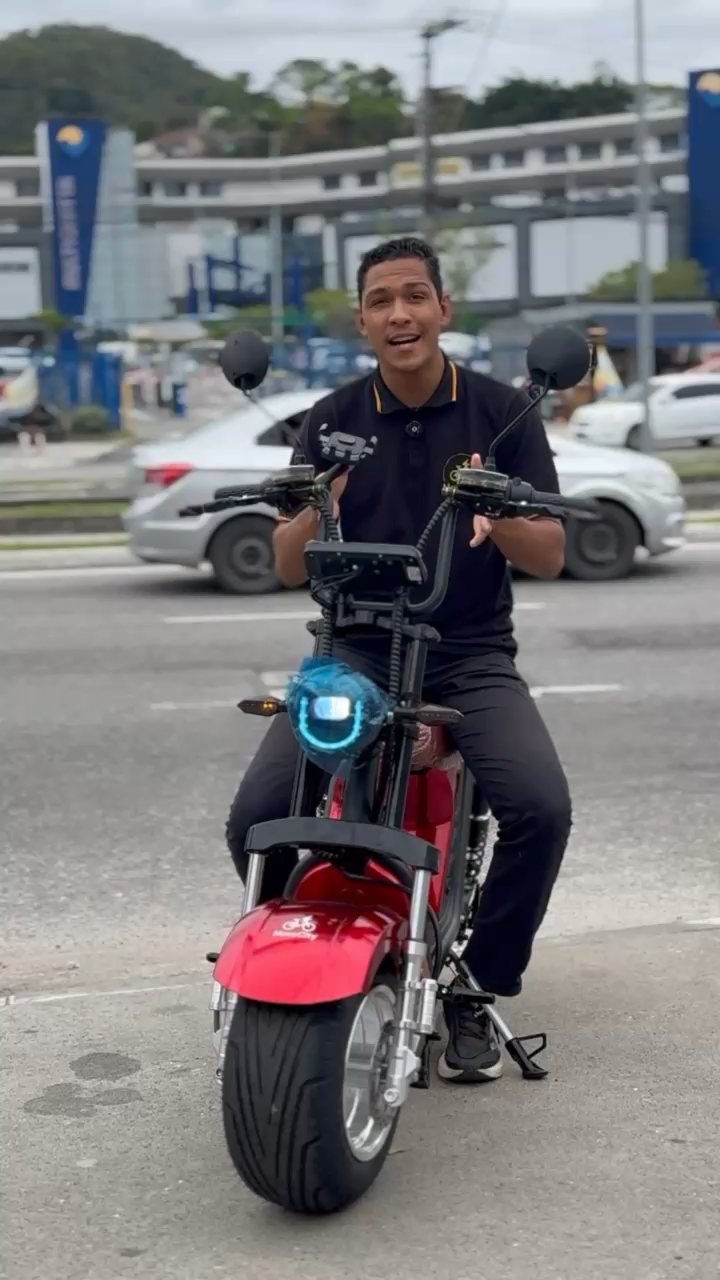 Pedro, da loja de Piratininga, com a moto el&eacute;trica na rua